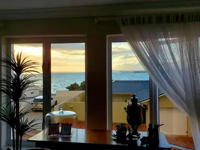 a view of the ocean from a room with windows at Gordon's Beach Lodge in Gordonʼs Bay