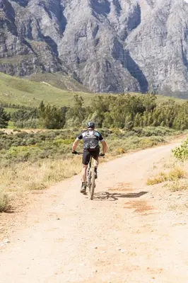 a man riding a bike down a dirt road at Eikehof Farm in Worcester