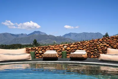 a pool with pillows next to a stone wall at Eikehof Farm in Worcester