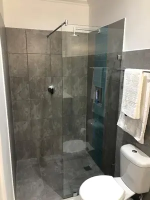 a bathroom with a glass shower with a toilet at Hermanus Guest Rooms in Hermanus