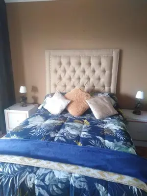 a bed with a blue blanket and pillows on it at Sir James Self Catering in Cape Town