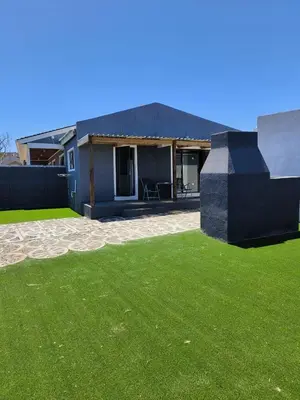 a house with a green lawn in front of it at Sir James Self Catering in Cape Town