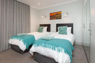two beds in a hotel room at Walker Bay Luxury Seafront Apartment in Hermanus