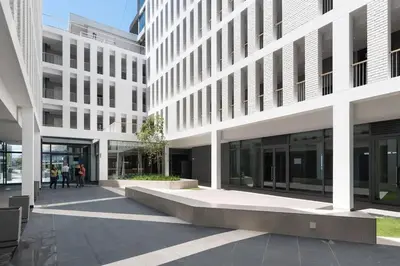 a large white building with people walking in front of it at Axis - Century City Self Catering Apartment in Cape Town