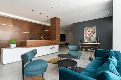 a living room with a blue couch and chairs at Axis - Century City Self Catering Apartment in Cape Town