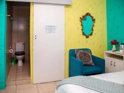 a room with a bed and a bathroom with a toilet at Relaxing Guest Huse in the heart of Ndabeni in Cape Town