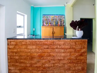 a brick counter in a room with a painting on the wall at Relaxing Guest Huse in the heart of Ndabeni in Cape Town