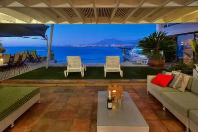 a living room with a view of the ocean at 185 on BEACH Boutique Suites in Gordonʼs Bay