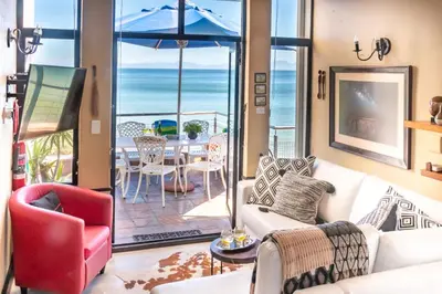 a living room with a view of the ocean at 185 on BEACH Boutique Suites in Gordonʼs Bay