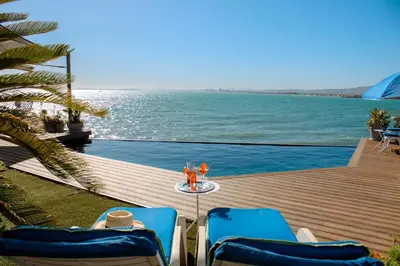 a view of the ocean from the deck of a resort at 185 on BEACH Boutique Suites in Gordonʼs Bay