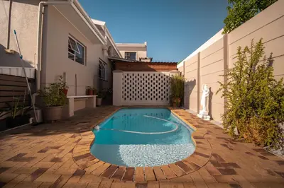 a swimming pool in the backyard of a house at Broadway Tygervalley House in Cape Town