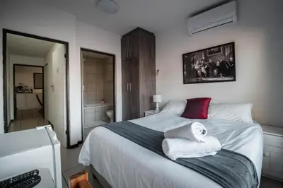 a bedroom with a large bed with towels on it at Broadway Tygervalley House in Cape Town