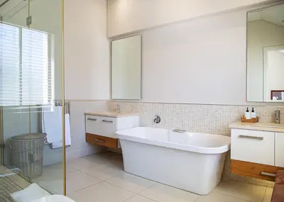 a bathroom with a white sink and a mirror at Marine Square Luxury Suites in Hermanus