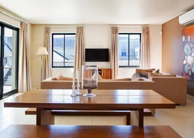 a living room with a table and a couch at Marine Square Luxury Suites in Hermanus