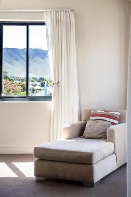 a living room with a chair and a window at Marine Square Luxury Suites in Hermanus