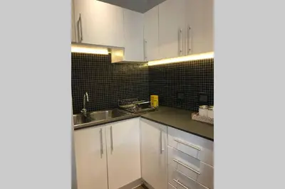 a kitchen with white cabinets and a sink at Winner in the Winelands in Franschhoek