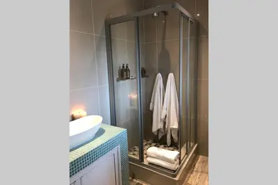 a bathroom with a glass shower and a sink at Winner in the Winelands in Franschhoek