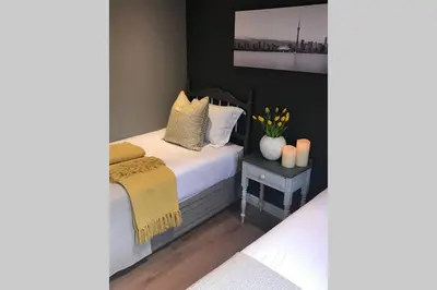 a bedroom with a bed with a yellow blanket at Winner in the Winelands in Franschhoek