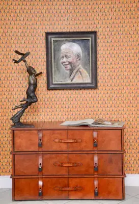 a painting of a man on a wall with a dresser at Church Street Luxury Apartments in Stellenbosch