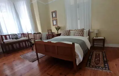 a bedroom with a large bed and a wooden floor at La Rochelle in Wellington