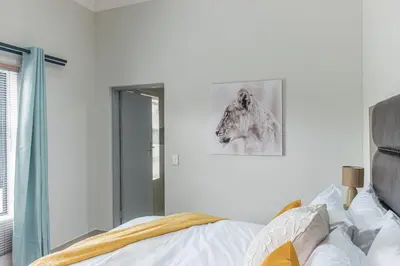 a bedroom with a bed and a mirror at Elizabeth House in Hermanus