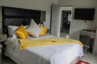a bedroom with a large bed with yellow pillows at Elizabeth House in Hermanus