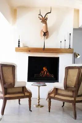 a living room with two chairs and a fireplace at Franschhoek Maison du Cap in Franschhoek