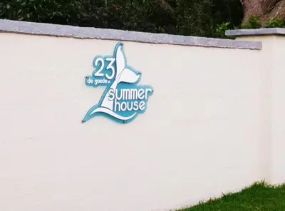 a sign for a summer house on a wall at Summer House in Hermanus