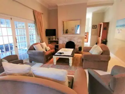 a living room with couches and a fireplace at Summer House in Hermanus
