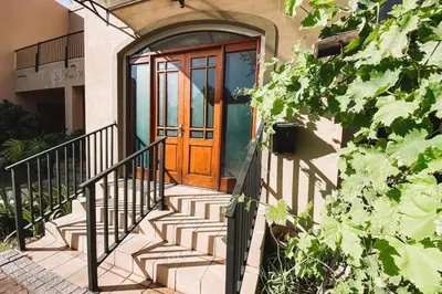 a wooden door with stairs in front of a house at Le Grec Wine Tram Apartment #1 in Franschhoek