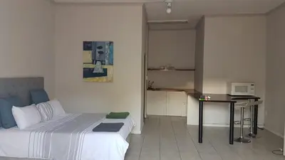a bedroom with a bed and a table in it at Le Grec Wine Tram Apartment #1 in Franschhoek