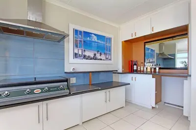 a kitchen with white cabinets and a stove top oven at Hermanus Beach Club - 106 - Apartment with a view in Hermanus