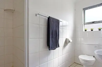 a bathroom with a toilet and a blue towel at Hermanus Beach Club - 106 - Apartment with a view in Hermanus