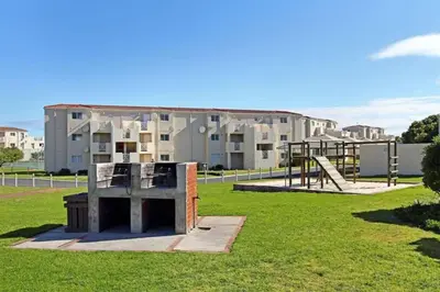 a park with a playground in front of a building at Hermanus Beach Club - 106 - Apartment with a view in Hermanus