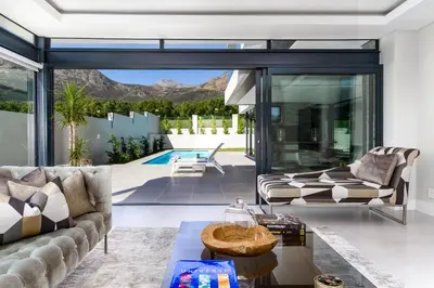 a living room with a couch and a table at Villa de luxe in Franschhoek