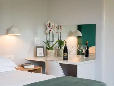 a bedroom with a table with wine bottles and glasses at Penguino Guesthouse in Hermanus