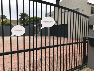 two speech bubbles on a fence in front of a house at Blouberg Studio Apartment in Bloubergstrand