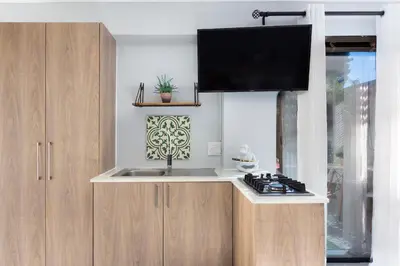 a kitchen with a sink and a tv above a stove at Blouberg Studio Apartment in Bloubergstrand
