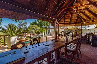 an outdoor dining area with a large wooden table at Villa Helderberg in Somerset West