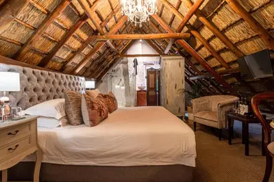 a bedroom with a large bed and a chandelier at Weltevreden Estate in Stellenbosch