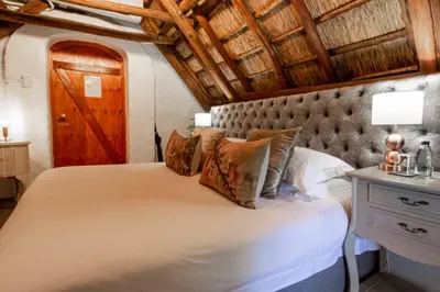 a bedroom with a large bed with a wooden ceiling at Weltevreden Estate in Stellenbosch