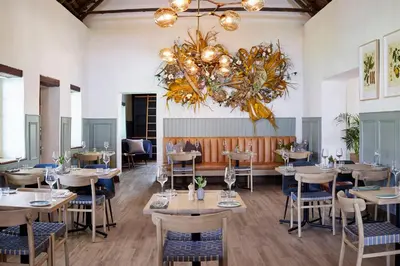 a restaurant with tables and chairs and a chandelier at Weltevreden Estate in Stellenbosch