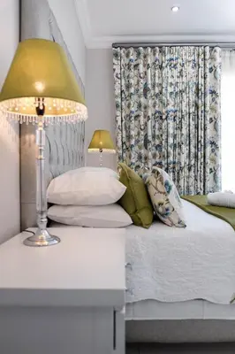 a bedroom with a bed with a lamp and a window at Hilltop Guesthouse in Bellville