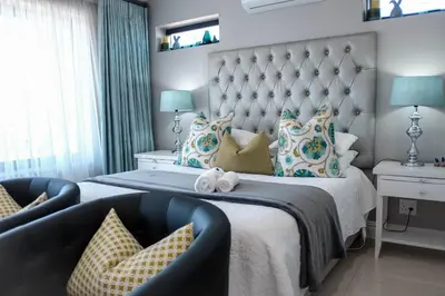 a bedroom with a large bed with a large headboard at Hilltop Guesthouse in Bellville