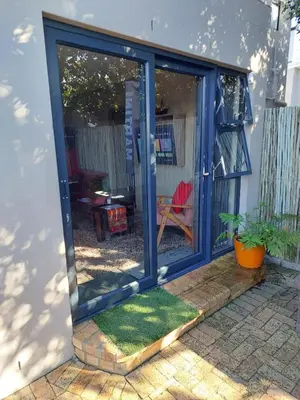a sliding glass door of a house with a yard at Karibu Self-catering Accommodation in Hermanus