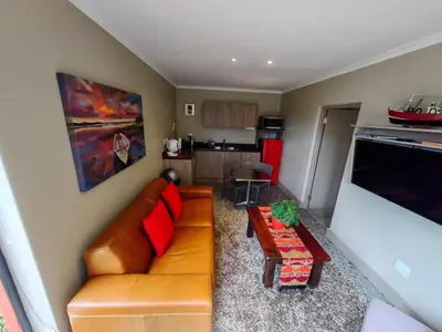 a living room with a couch and a table at Karibu Self-catering Accommodation in Hermanus
