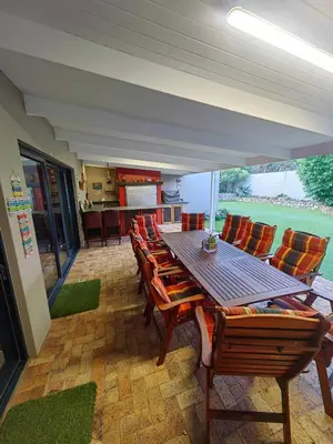 a dining room with a wooden table and chairs at Karibu Self-catering Accommodation in Hermanus