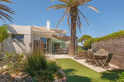 a house with a palm tree in the yard at Kite View Villa @2 in Cape Town