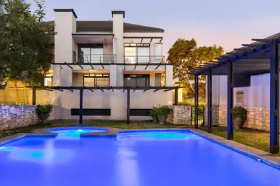 a house with a swimming pool in front of a house at Waterstone East F201 in Cape Town