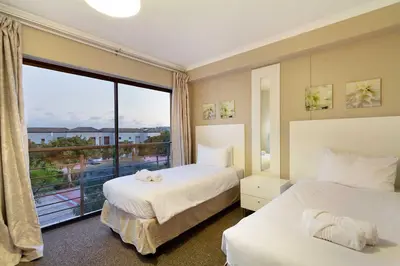 a hotel room with two beds and a large window at Waterstone East F201 in Cape Town